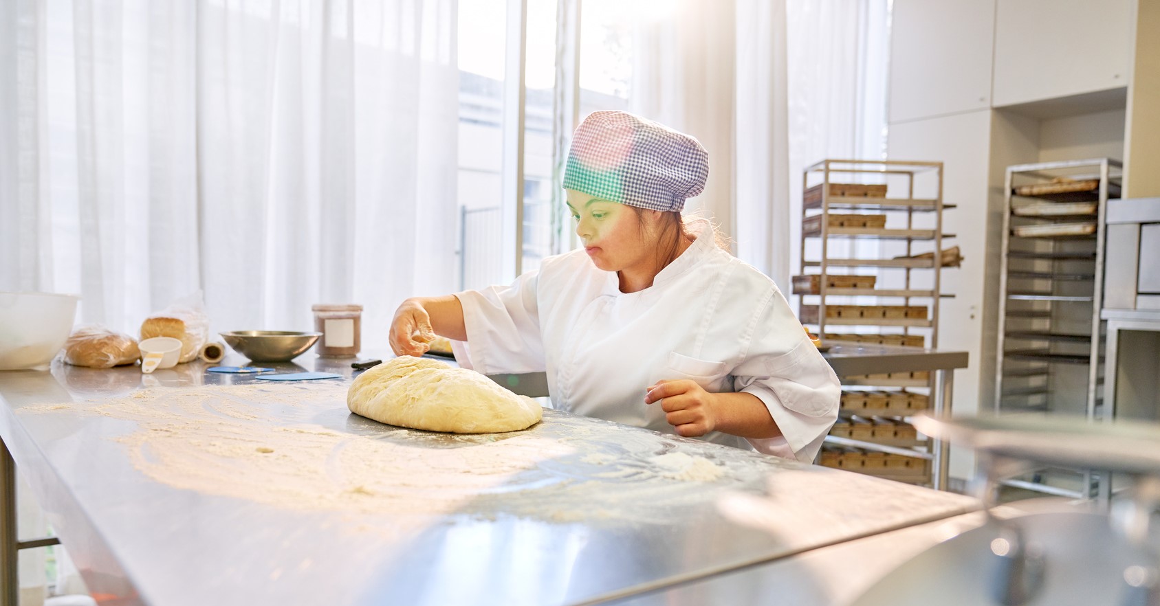 woman wearing a chef hat using a stand mixer